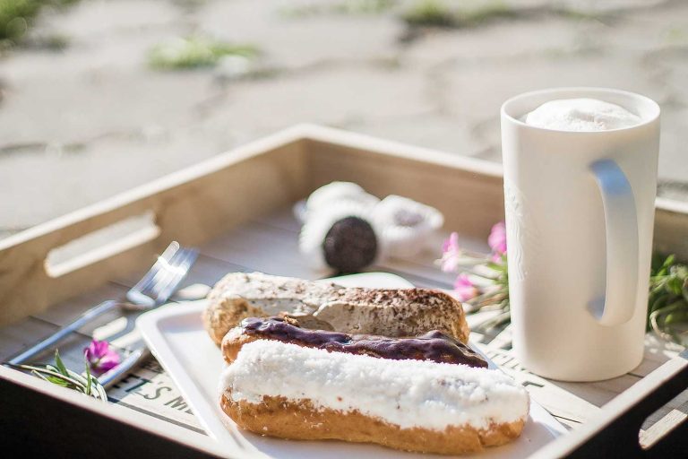 sweet eclair on tray on the beach