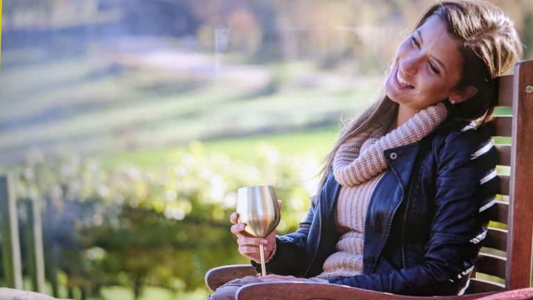 woman holding gold wine glass outside