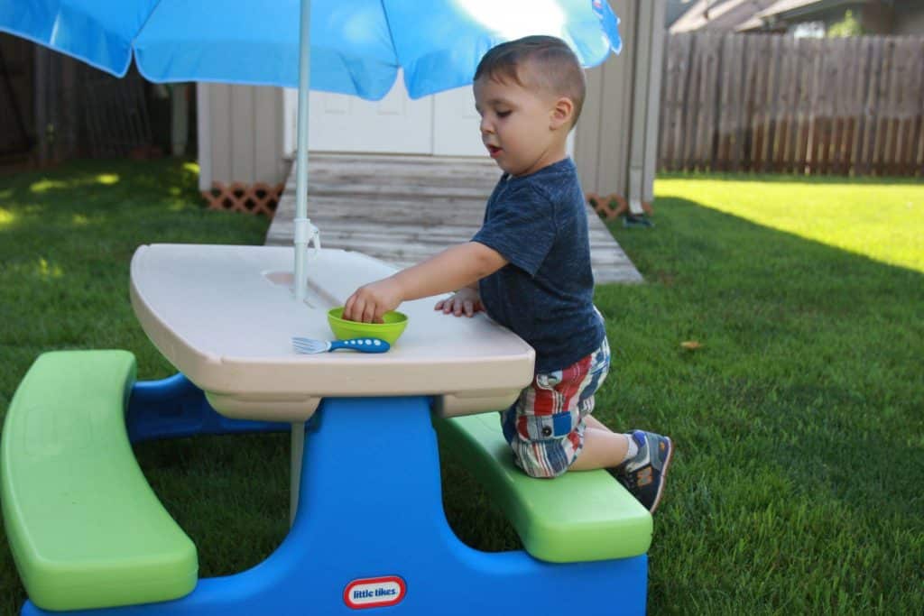 kid playing at small picnic table