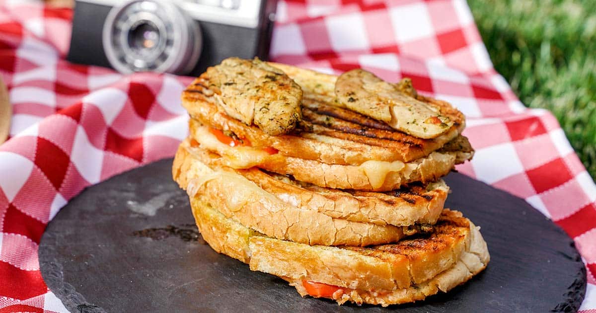 Chicken Caprese Panini, Stacked sandwiches with camera in background.