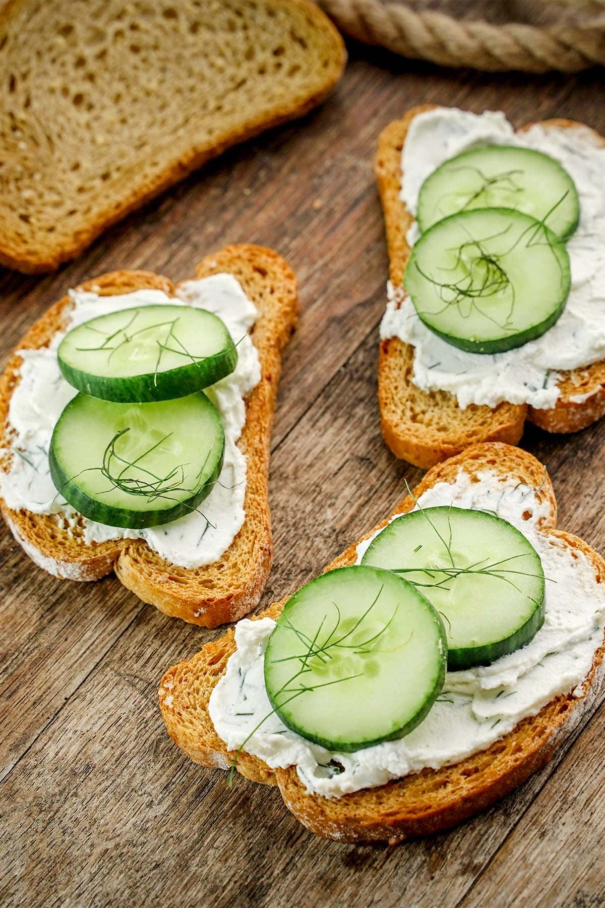Cucumber Dill Toast Sandwiches on board and rope.