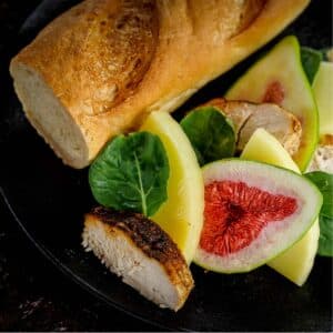 Fig and Chicken Baguette Sandwich, on black plate not put together.