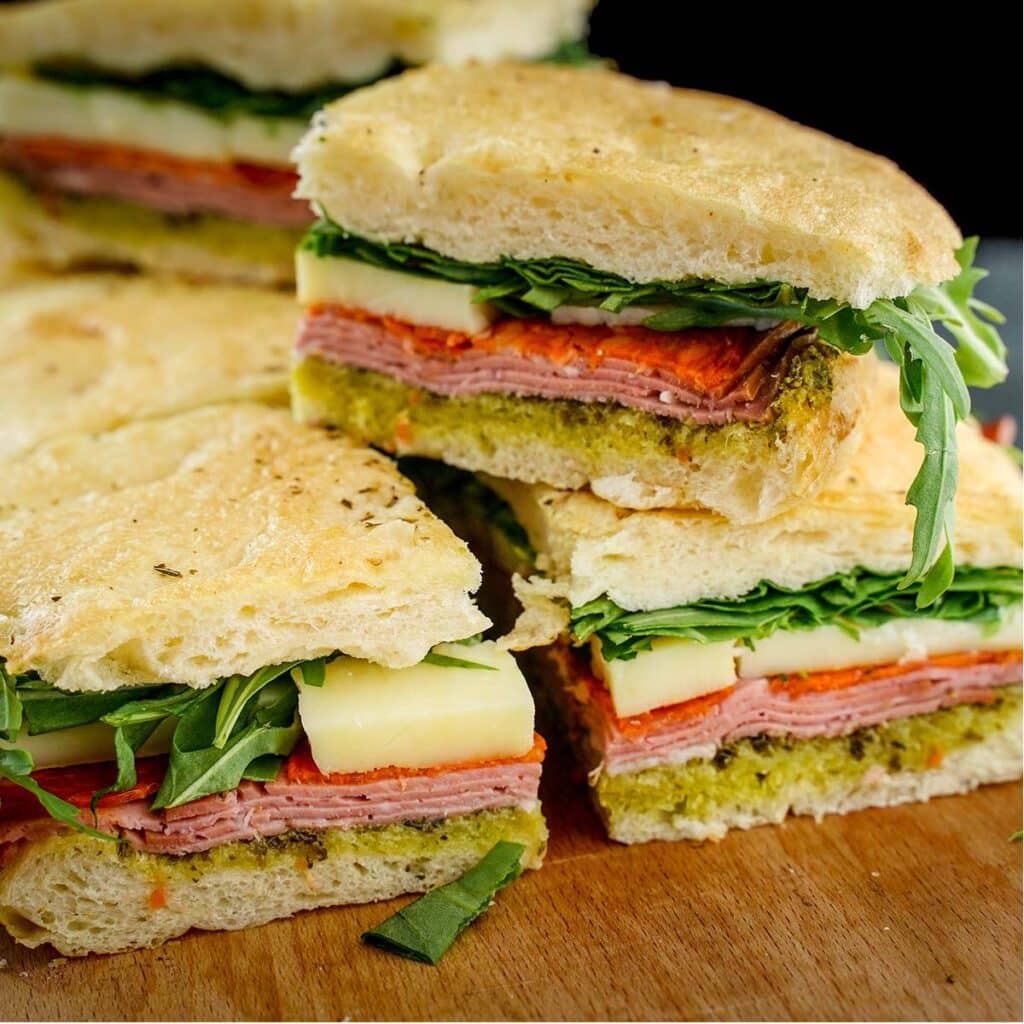 Italian Pesto Sandwich, stacked on cutting board.