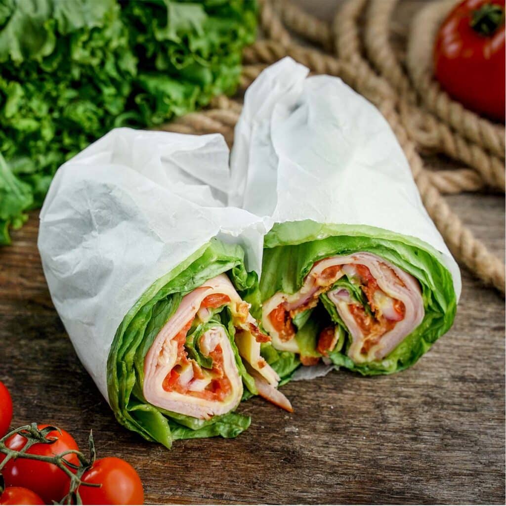 Lettuce Wrap Sandwich, with rope, lettuce and tomato in background.