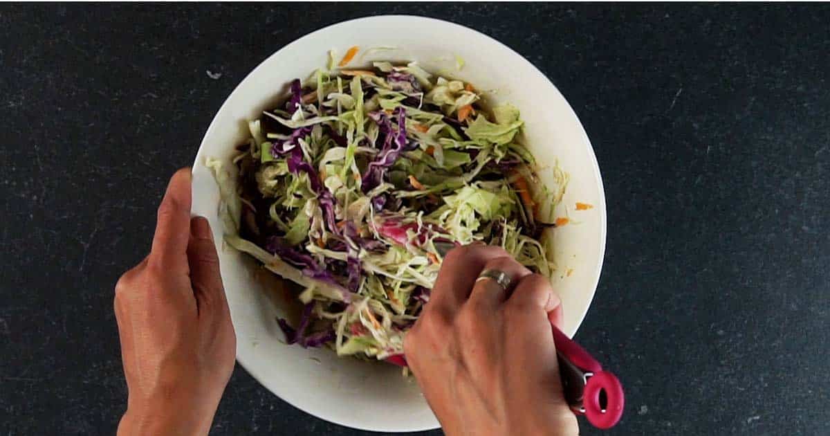 Mixing slaw ingredients together for Coleslaw Swiss cheese melt.