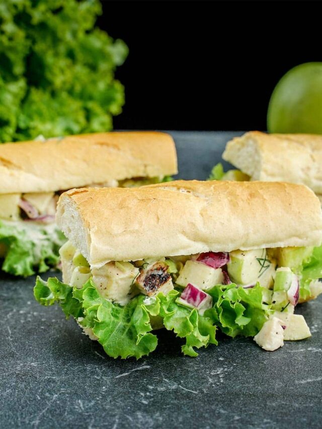 Three Chicken Salad Sandwiches on black slate.