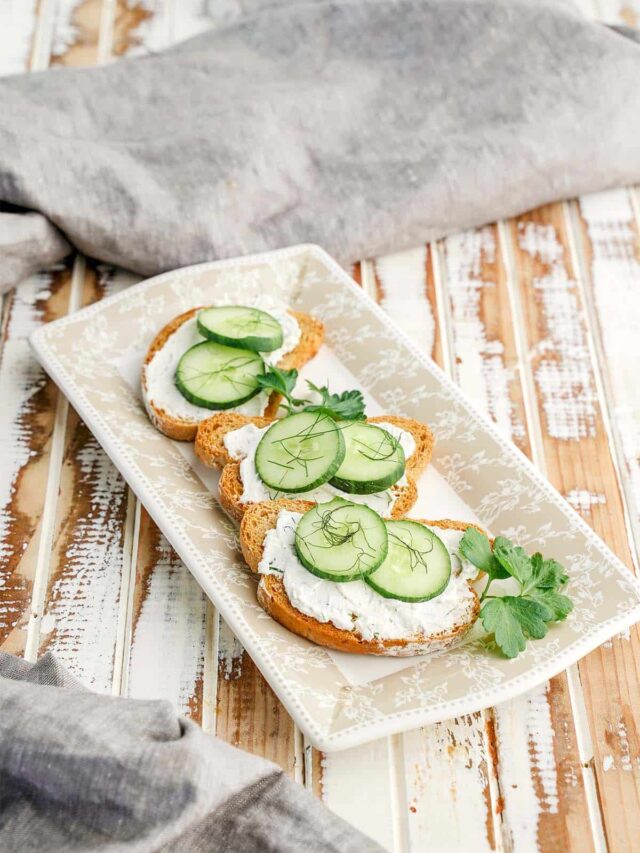 Cucumber Dill Toast Sandwich on platter and whitewash board grey towel.