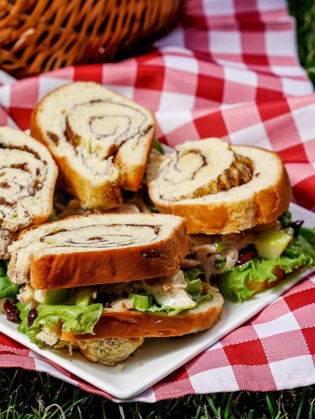 Chicken Waldorf sandwich, on white plate with checkered towel.