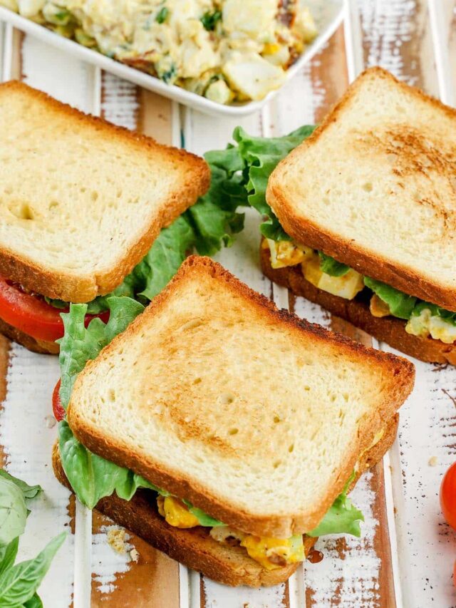 Egg salad sandwich, times 3. Salad at the top on a plate.