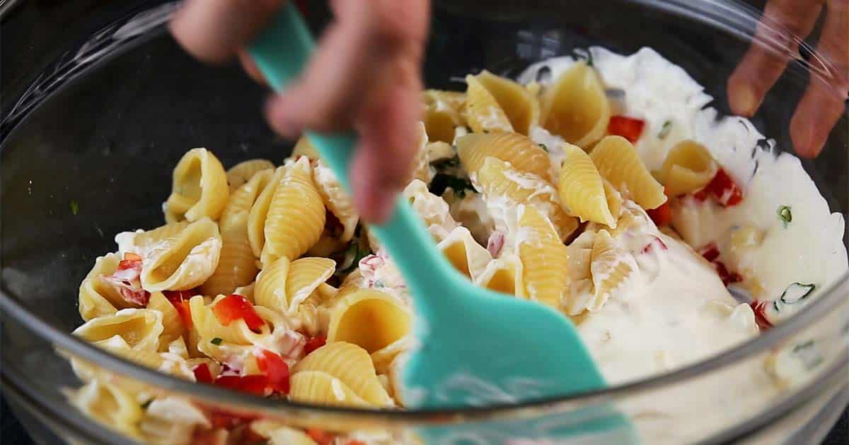 stirring ingredients to make garden pasta salad