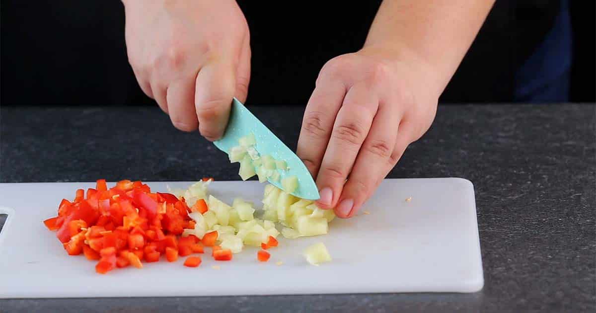 chopping ingredients to make garden pasta salad