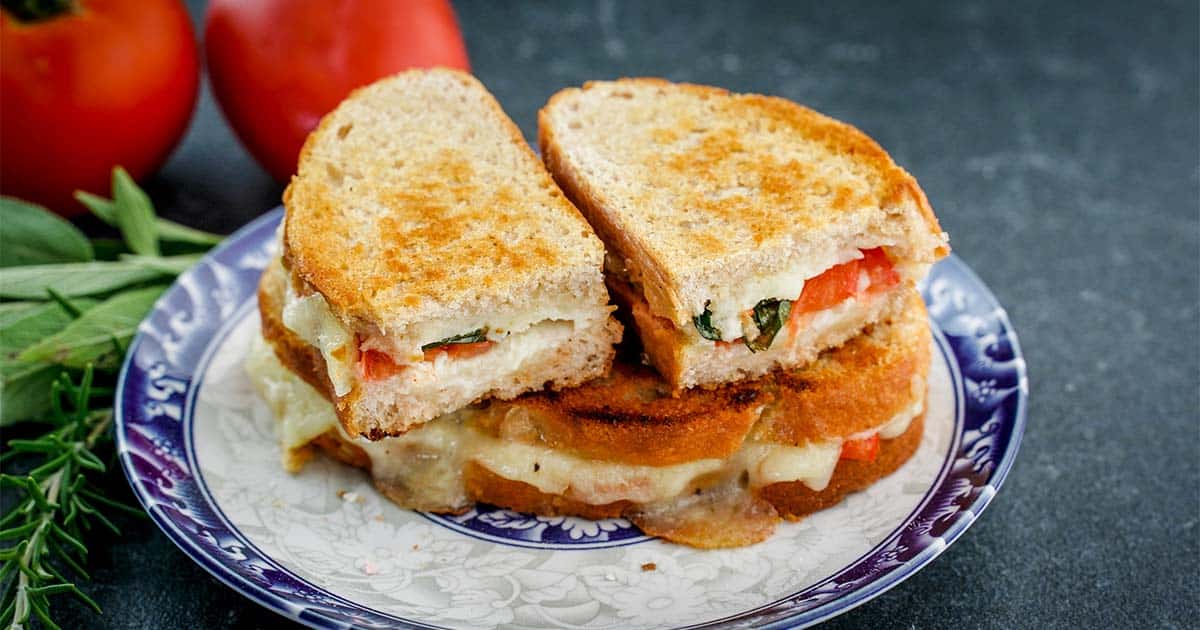 closeup of heirloom tomato and basil grilled cheese sandwich