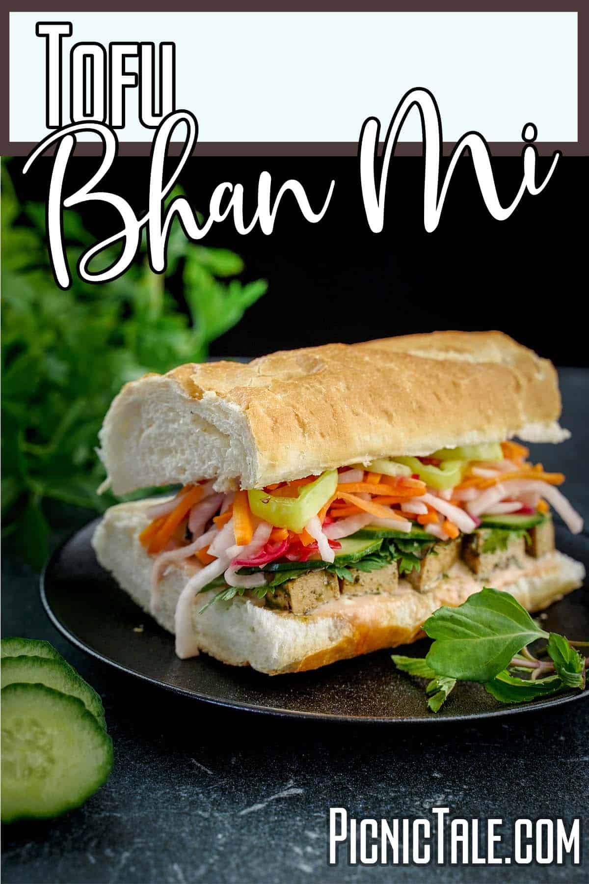 Tofu Bhan Mi sandwich on black plate wording on top.