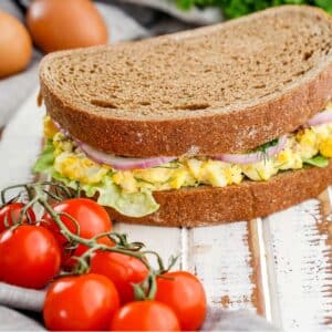 Ultimate egg salad sandwich, cherry tomato and eggs in background.