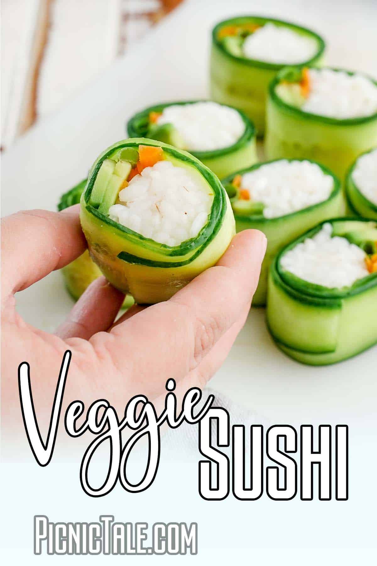 hand holding a vegetable sushi roll with text which reads veggie sushi